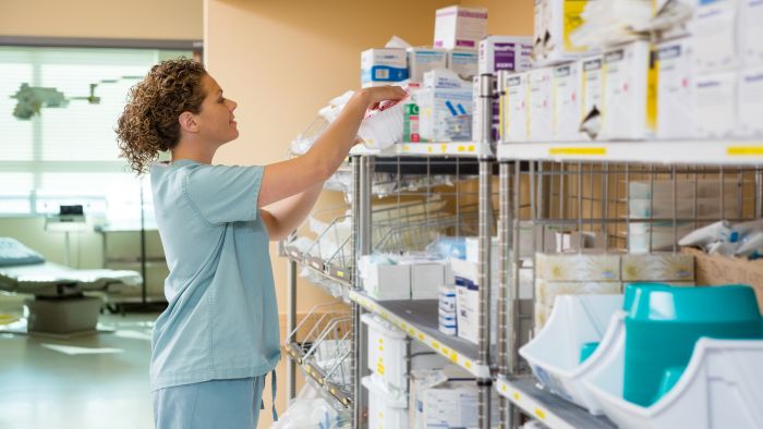 Side view of female nurse working in storage room of cancer hospital