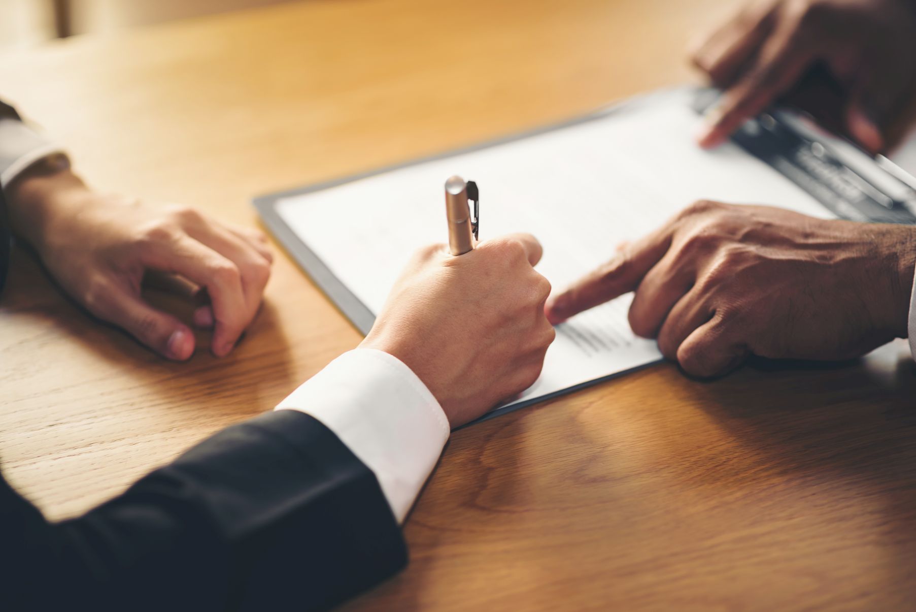 The hand of a business man is using the index finger to let the customer sign the contract, contract, business agreement.