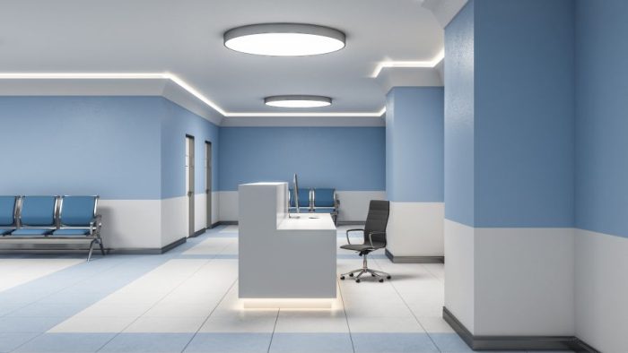 Modern reception desk with computer in blue medical office interior. Medical and healthcare concept. 3D Rendering