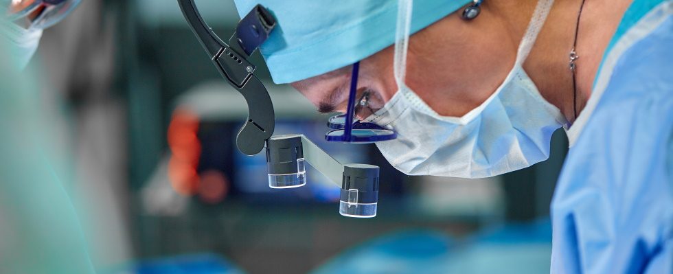 A surgeon's team in uniform performs an operation on a patient at a cardiac surgery clinic. Modern medicine, a professional team of surgeons, health